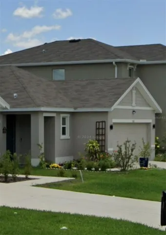 a front view of a house with a garden and plants