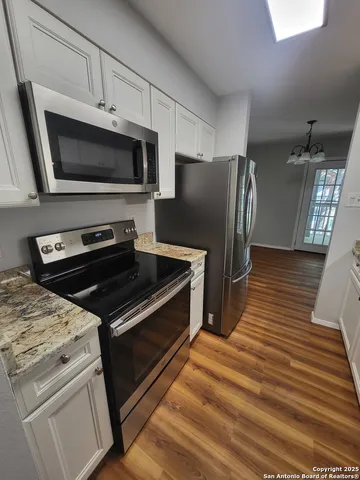 a kitchen with wooden cabinets and stainless steel appliances