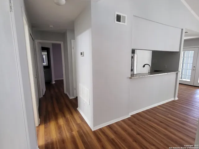 a view of a hallway with wooden floor and staircase