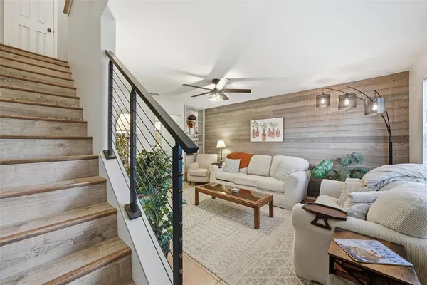 a living room with furniture and a ceiling fan