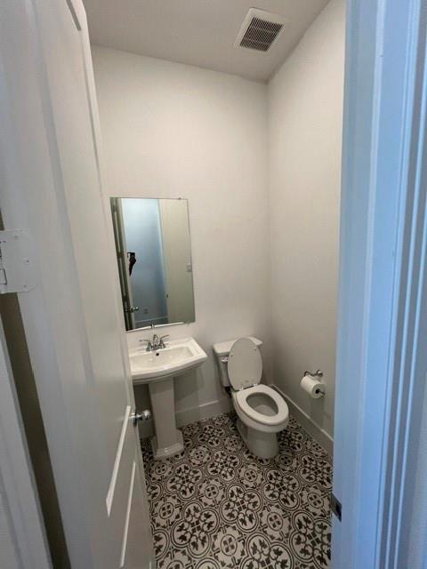 1407 Cartona Road Fate, TX 75087 - Photo 8 of 21 Powder room with patterned tile flooring, a pedestal sink, and a wall-mounted mirror