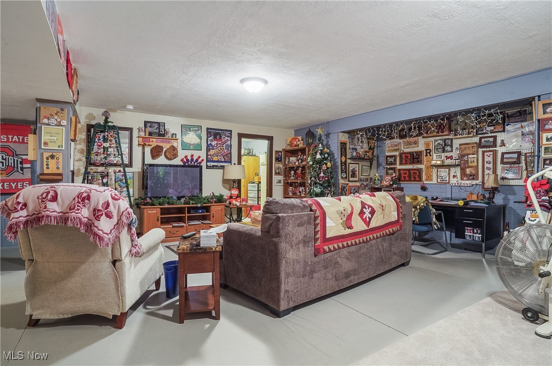 861 Susan Road Ravenna, OH 44266 - Photo 34 of 45 Basement Living room featuring a textured ceiling and concrete floors