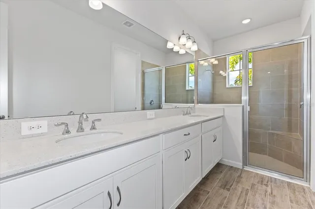 a spacious bathroom with double vanity and a mirror
