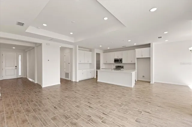 a view of kitchen with kitchen island white cabinets and wooden floor