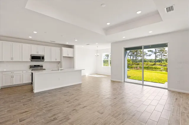 a view of kitchen with granite countertop cabinets and window