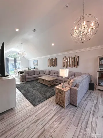 a living room with furniture and a chandelier