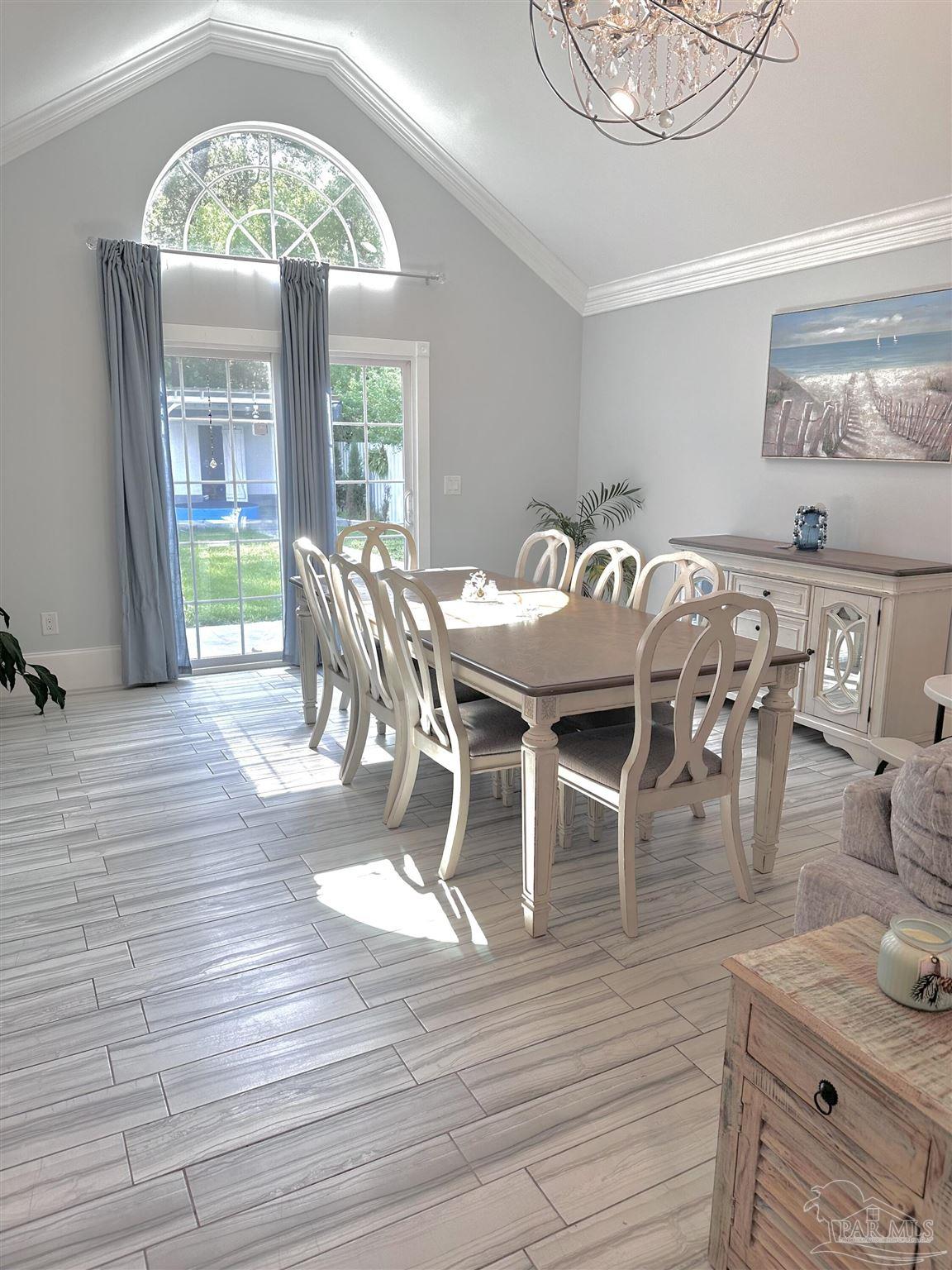3097 Fayal Drive Pensacola, FL 32526 - Photo 17 of 46 a dining room with wooden floor a chandelier a wooden table and chairs