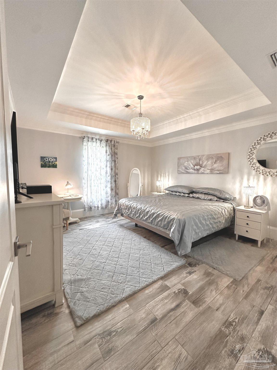 3097 Fayal Drive Pensacola, FL 32526 - Photo 20 of 46 a spacious bedroom with a bed and a chandelier