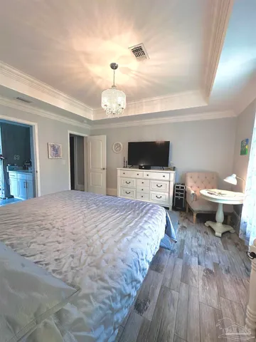 a spacious bedroom with a bed and a flat screen tv