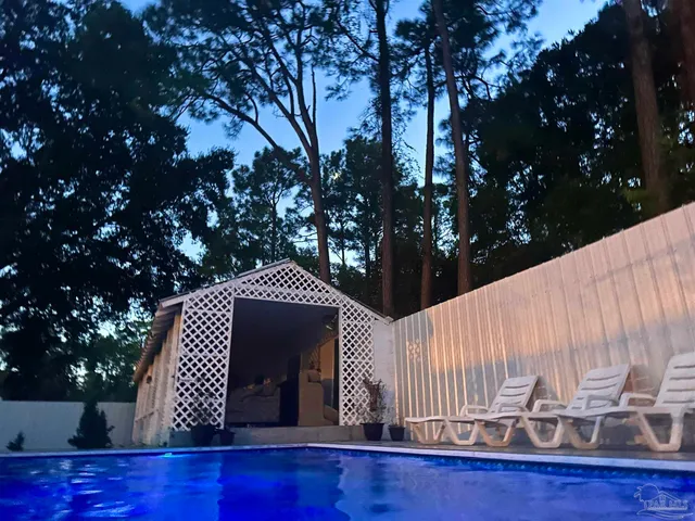 a view of a patio with table and chairs potted plants and large tree