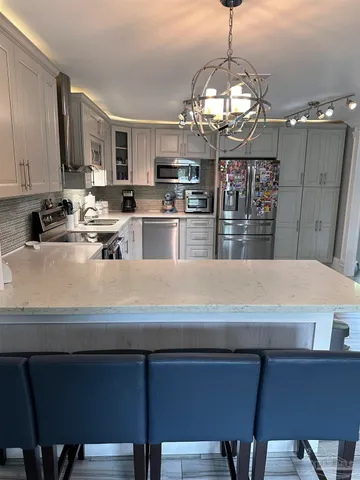 a open kitchen with stainless steel appliances granite countertop a stove and a wooden floors