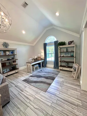 a living room with furniture chandelier and wooden floor