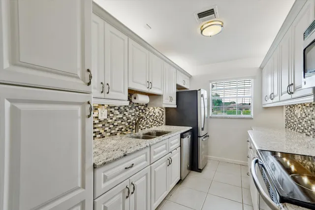 a kitchen with stainless steel appliances granite countertop a refrigerator and a stove