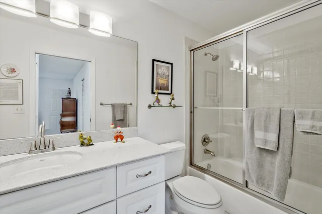 a bathroom with a sink vanity granite toilet and shower