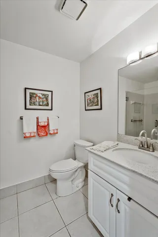 a bathroom with a granite countertop sink mirror vanity and toilet