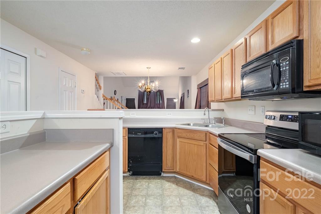 16865 Timber Crossing Road Charlotte, NC 28213 - Photo 22 of 36 a kitchen with stainless steel appliances granite countertop a sink stove and cabinets