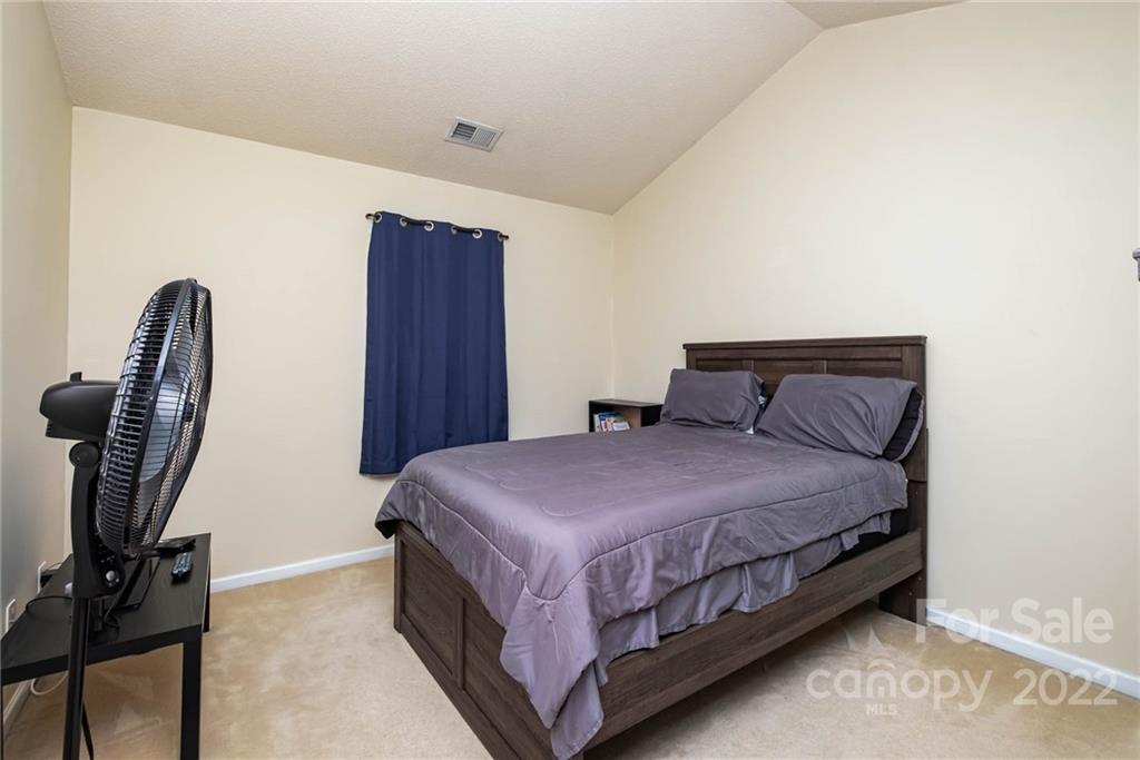 16865 Timber Crossing Road Charlotte, NC 28213 - Photo 32 of 36 a bedroom with a bed a dresser and wooden floor