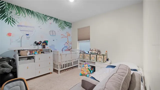 a bedroom with furniture and baby crib