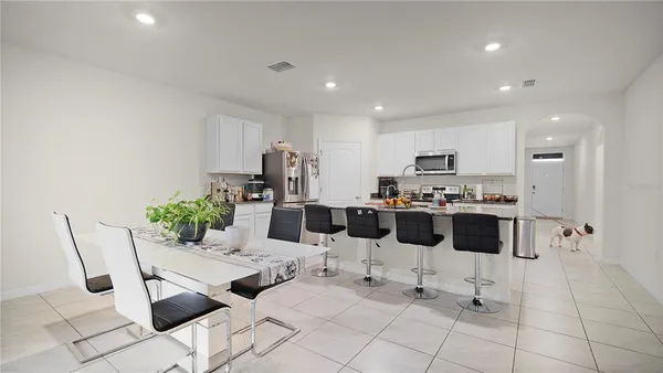 a kitchen with stainless steel appliances kitchen island granite countertop a refrigerator and white cabinets