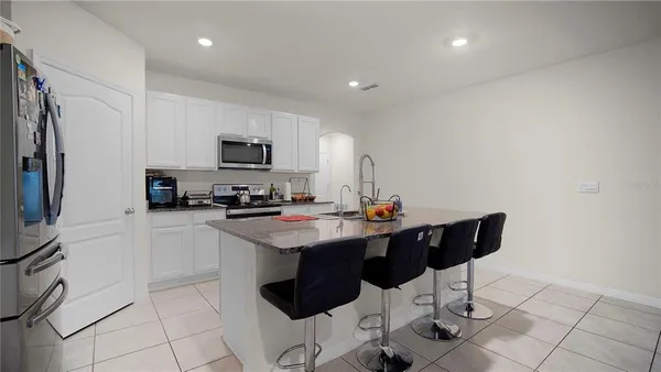 a kitchen with stainless steel appliances kitchen island granite countertop a sink and a stove