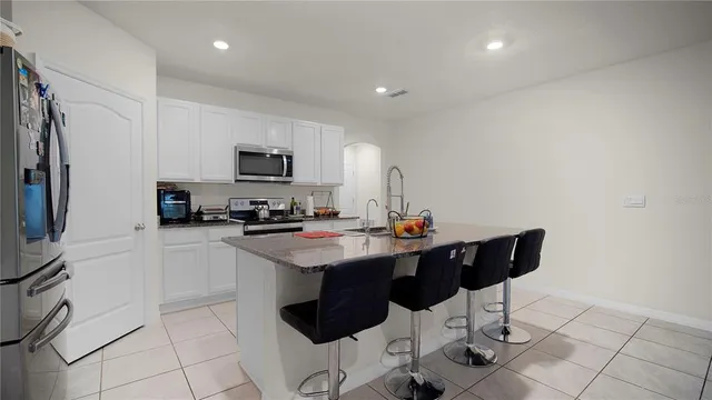 a kitchen with stainless steel appliances kitchen island granite countertop a sink and a stove