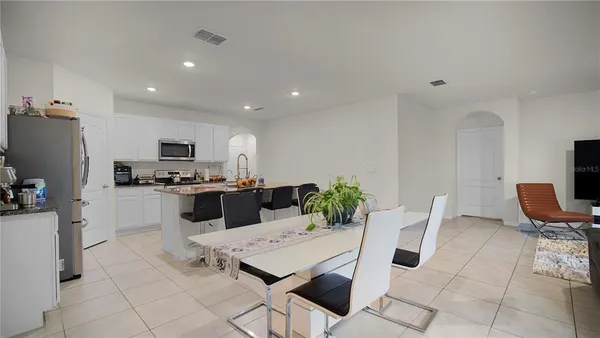 a kitchen with stainless steel appliances kitchen island granite countertop a sink and a refrigerator