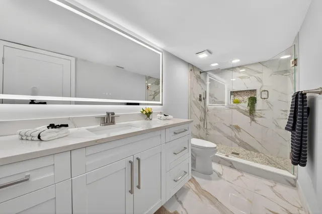 a bathroom with a double vanity sink toilet mirror and bathtub