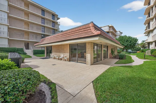 a view of house with a yard and potted plants