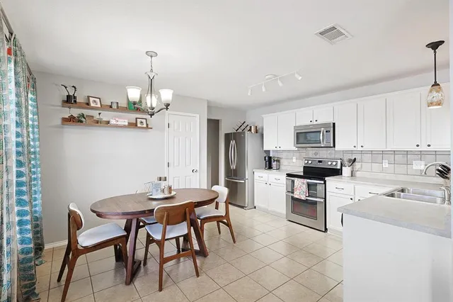 a view of kitchen with cabinets table and chairs
