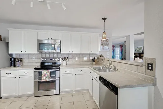 a kitchen with a sink stove top oven and cabinets