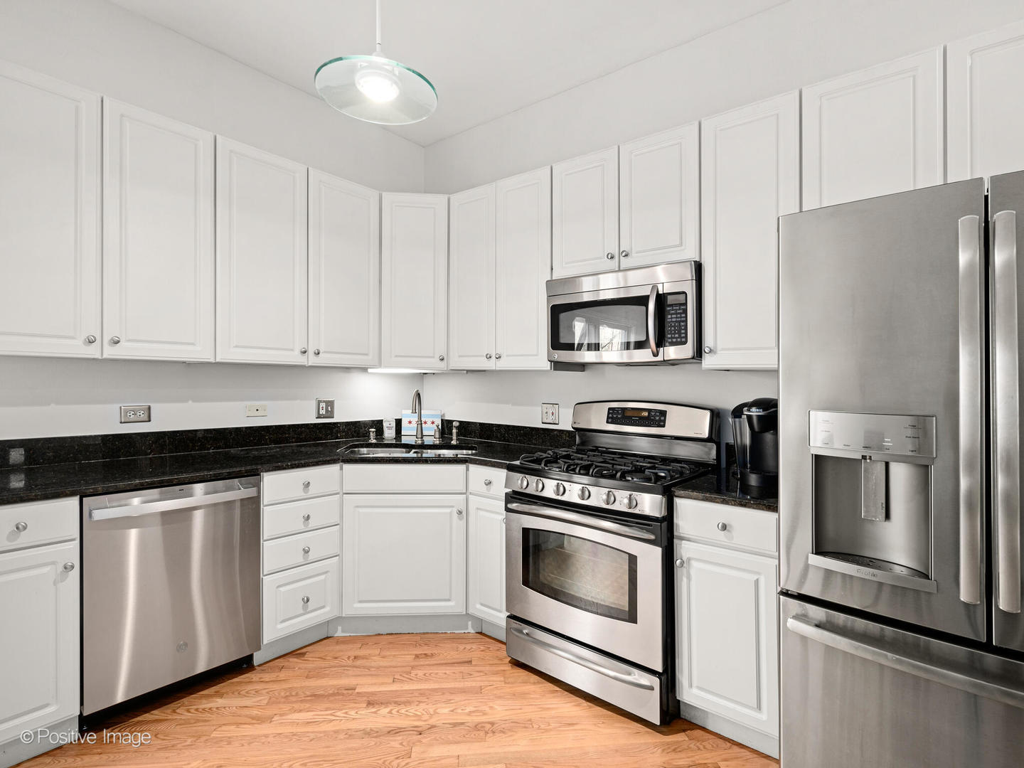 855 West Erie Street, Unit 107 Chicago, IL 60642 - Photo 5 of 21 a kitchen with white cabinets stainless steel appliances and sink