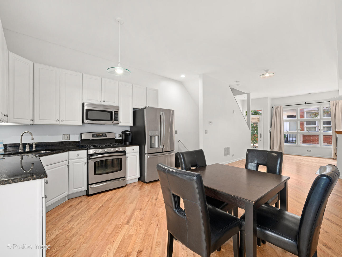 855 West Erie Street, Unit 107 Chicago, IL 60642 - Photo 6 of 21 a kitchen with stainless steel appliances a table chairs microwave and refrigerator