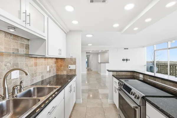 a kitchen with stainless steel appliances granite countertop a sink and a stove