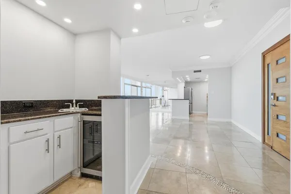 a kitchen with a refrigerator and white cabinets