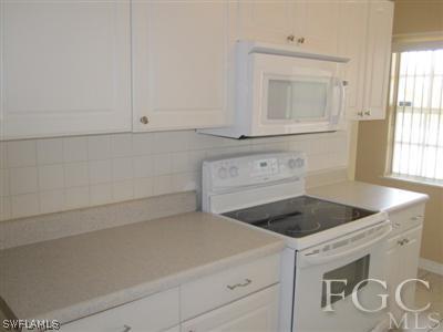 2120 Earl Road Fort Myers, FL 33901 - Photo 9 of 10 a kitchen with a stove microwave and cabinets