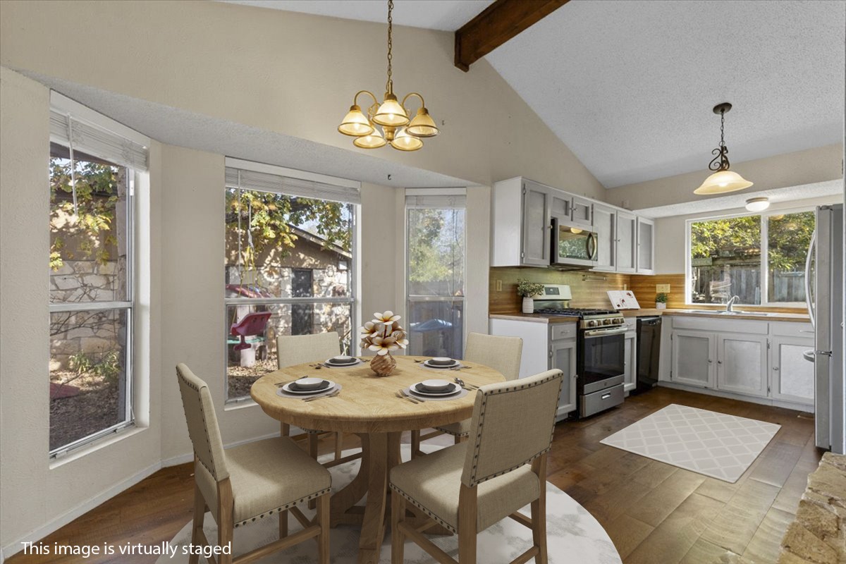 511 Suzzane Road Pflugerville, TX 78660 - Photo 11 of 37 Dining space featuring dark wood finished floors, a chandelier, beam ceiling, and high vaulted ceiling