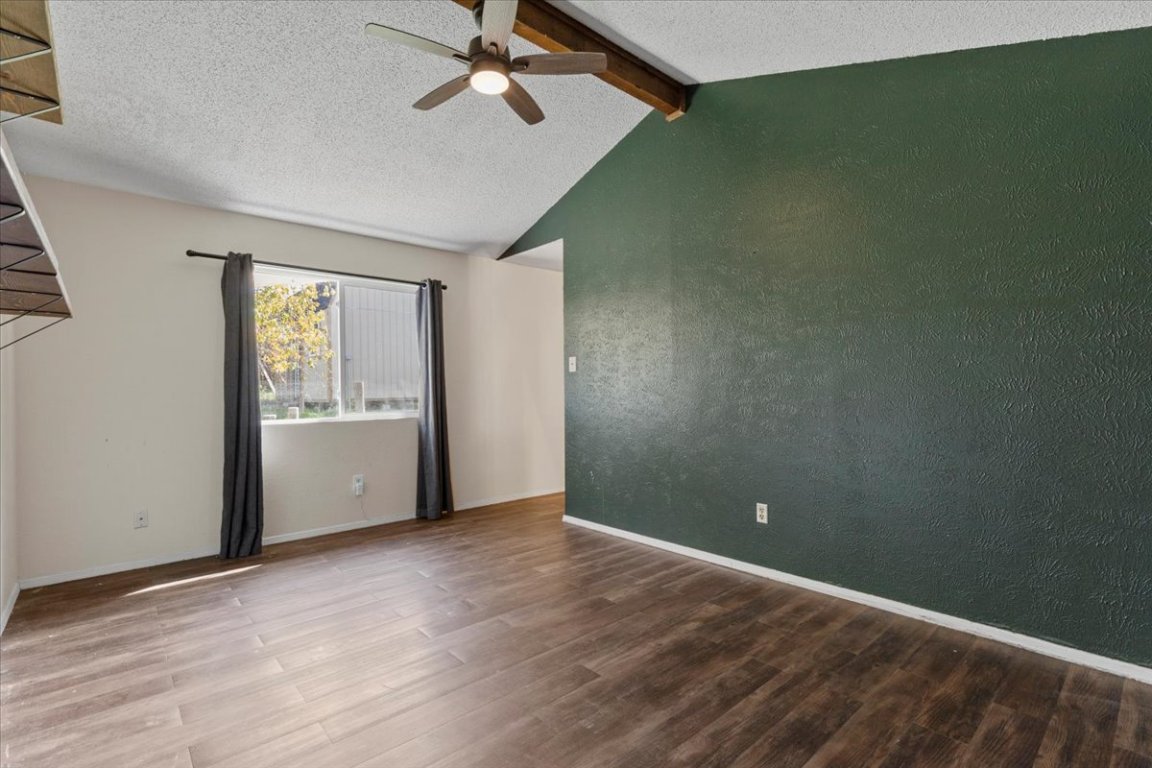 511 Suzzane Road Pflugerville, TX 78660 - Photo 13 of 34 Primary room featuring a textured ceiling, wood finished floors, a ceiling fan, and a textured wall