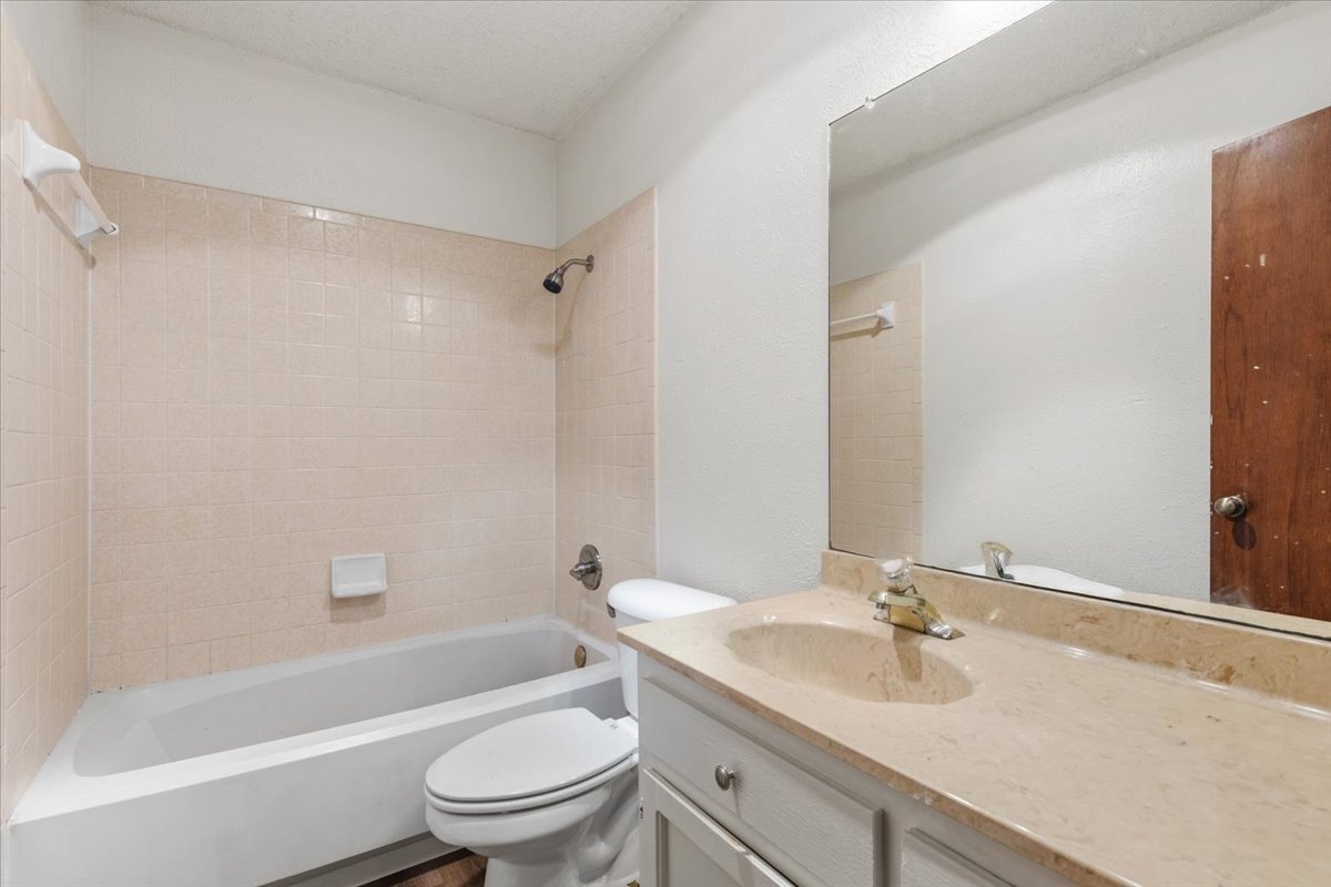 511 Suzzane Road Pflugerville, TX 78660 - Photo 19 of 35 a bathroom with a granite countertop sink a toilet and a bathtub