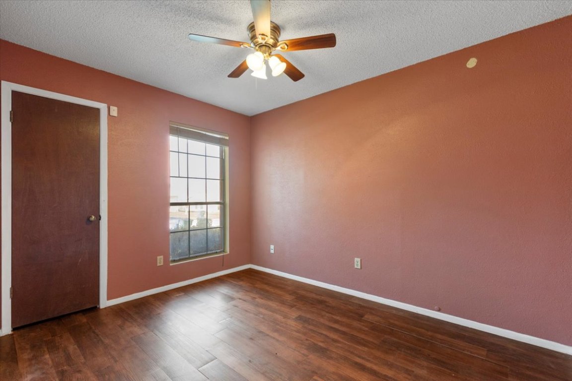 511 Suzzane Road Pflugerville, TX 78660 - Photo 23 of 34 Spare room featuring a textured ceiling, dark wood-style floors, and ceiling fan