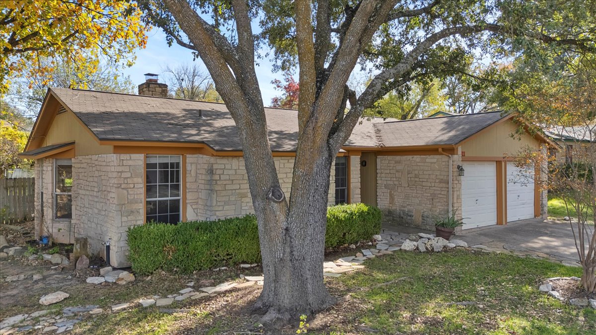 511 Suzzane Road Pflugerville, TX 78660 - Photo 3 of 34 View of front facade featuring a chimney, stone siding, and a shingled roof