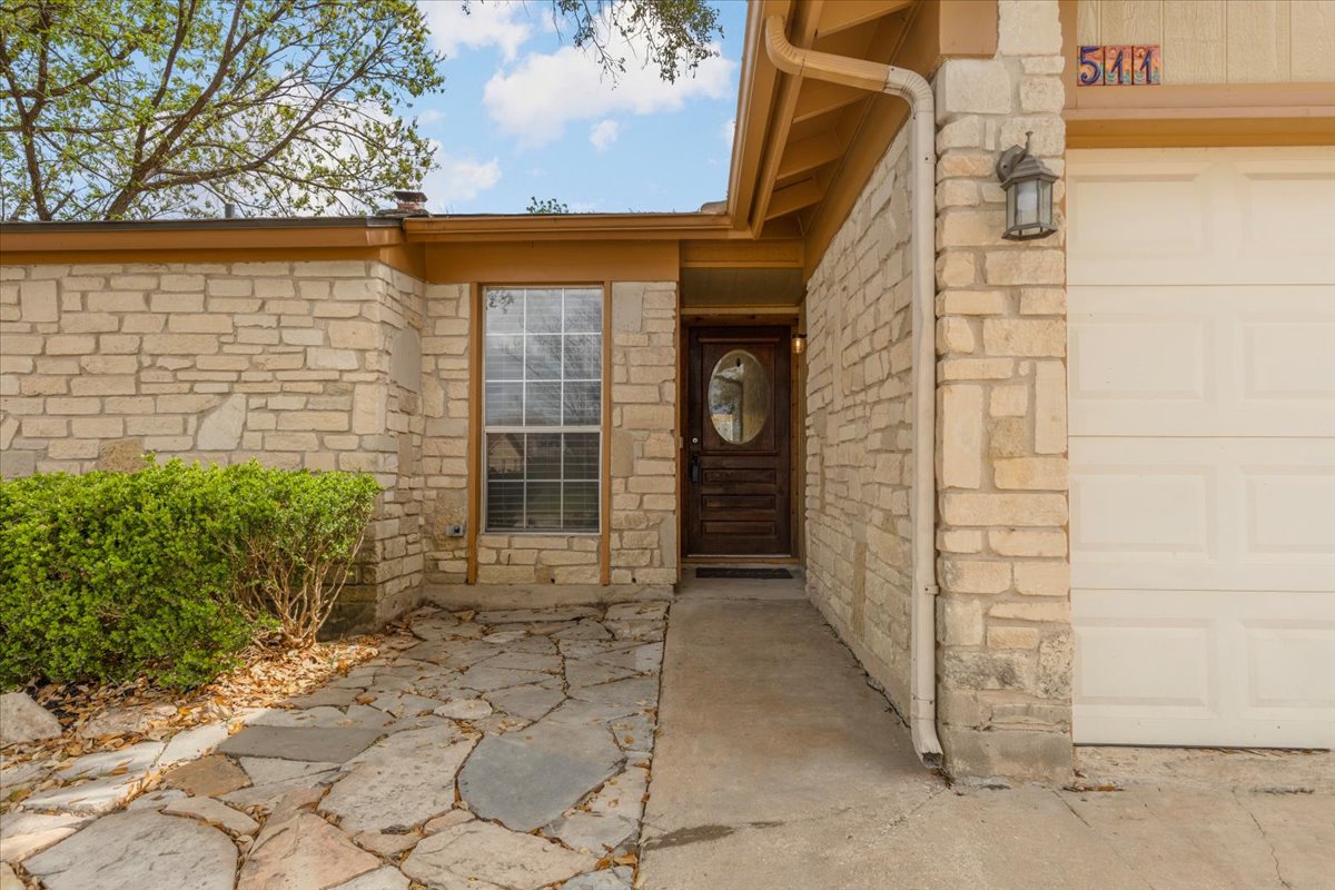 511 Suzzane Road Pflugerville, TX 78660 - Photo 4 of 35 Property entrance featuring stone siding and a garage