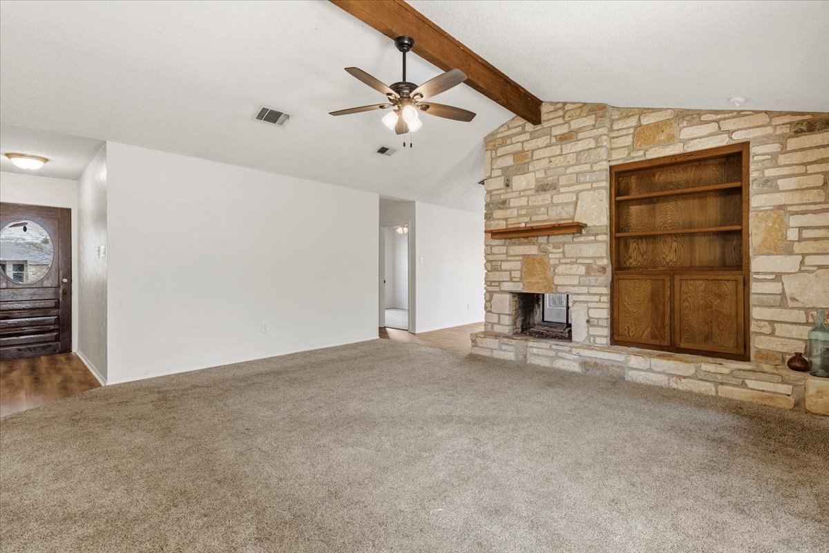 511 Suzzane Road Pflugerville, TX 78660 - Photo 5 of 35 Living room featuring a ceiling fan, a fireplace, carpet, beam ceiling, and built in features
