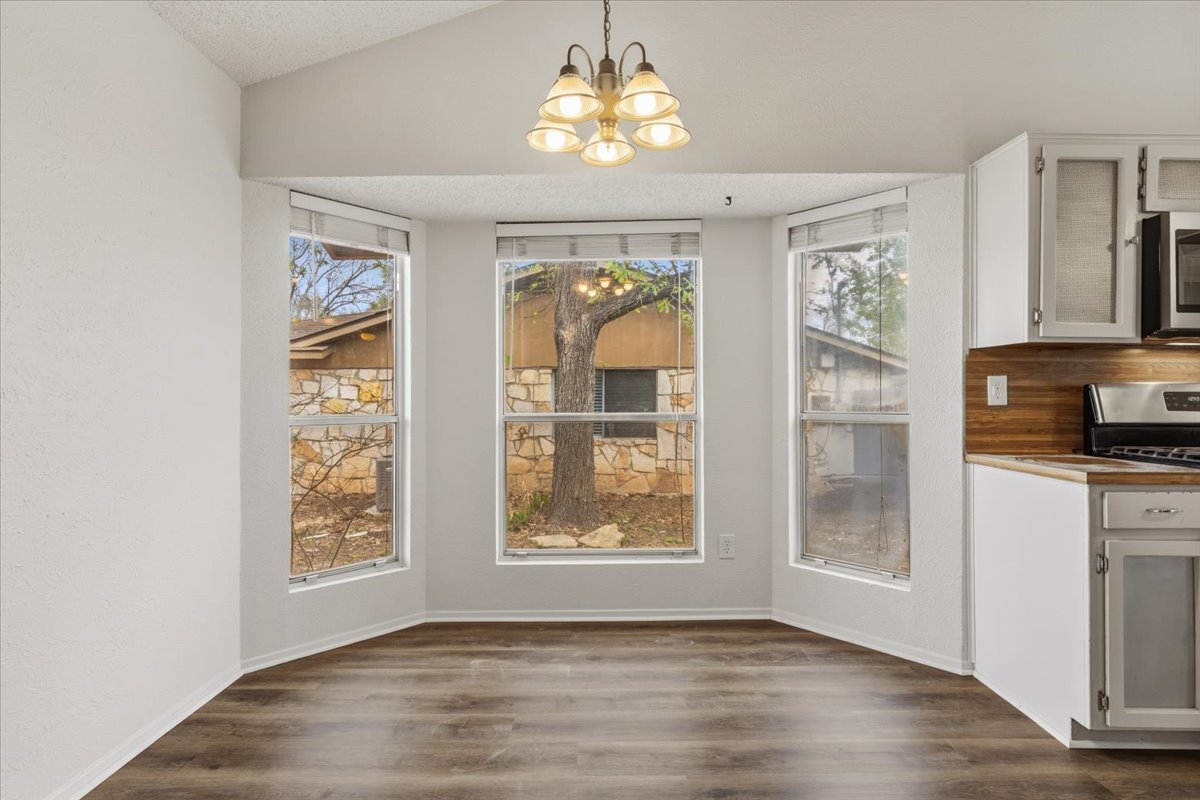511 Suzzane Road Pflugerville, TX 78660 - Photo 7 of 35 a view of an empty room with a window and wooden floor