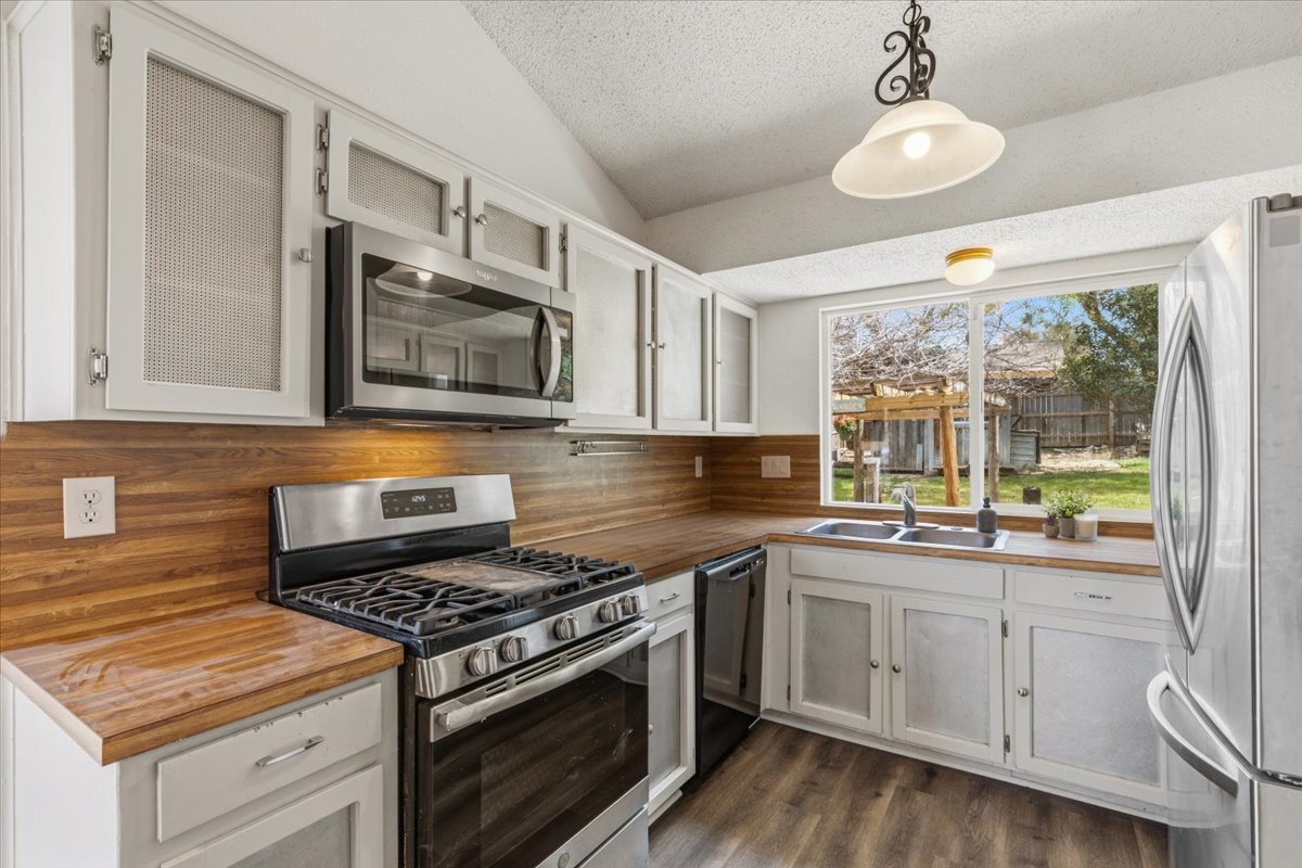511 Suzzane Road Pflugerville, TX 78660 - Photo 10 of 35 a kitchen with stainless steel appliances white cabinets granite counter tops and a window