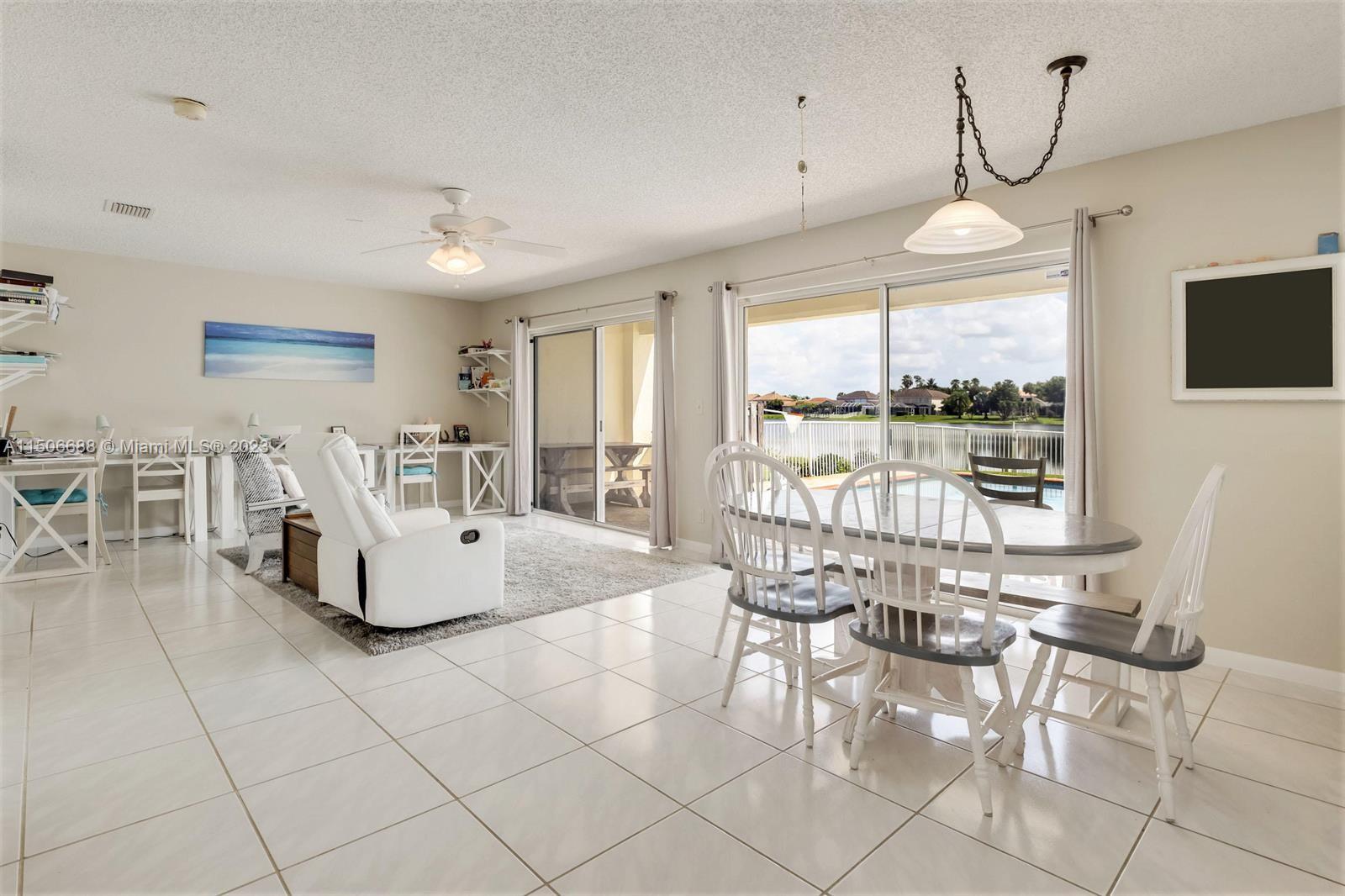 7289 Shell Ridge Terrace Lake Worth, FL 33467 - Photo 12 of 55 a living room with furniture a flat screen tv and large windows