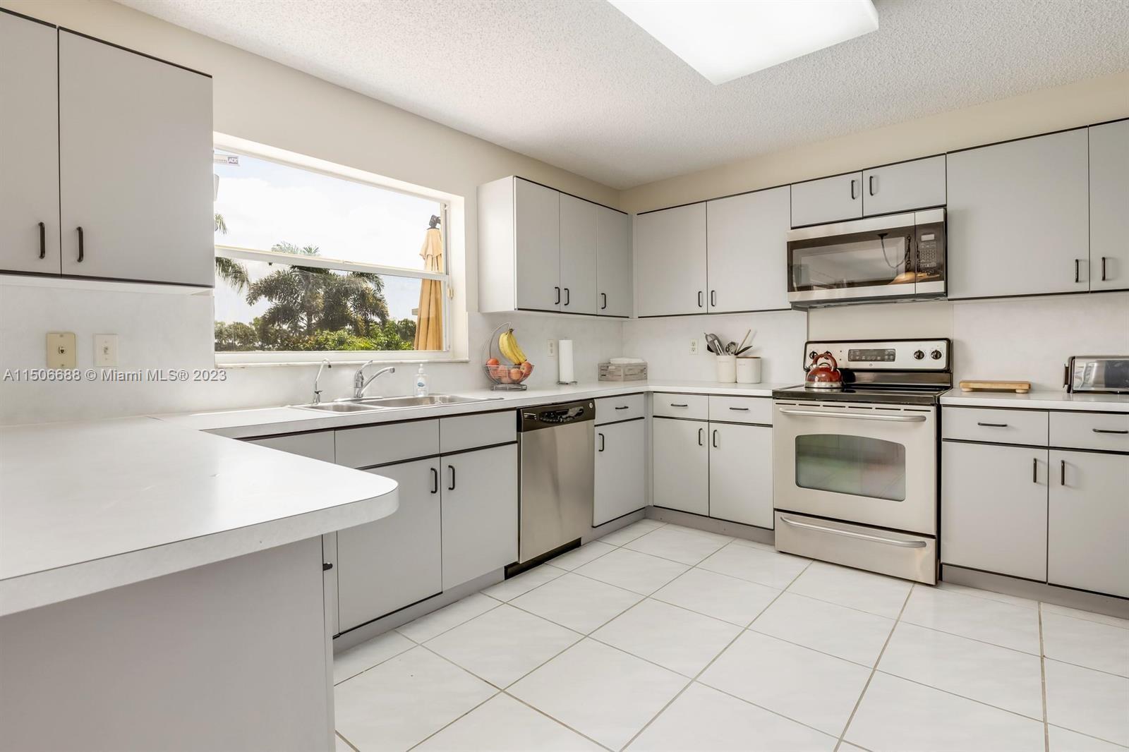 7289 Shell Ridge Terrace Lake Worth, FL 33467 - Photo 15 of 55 a kitchen with stainless steel appliances granite countertop a sink and cabinets