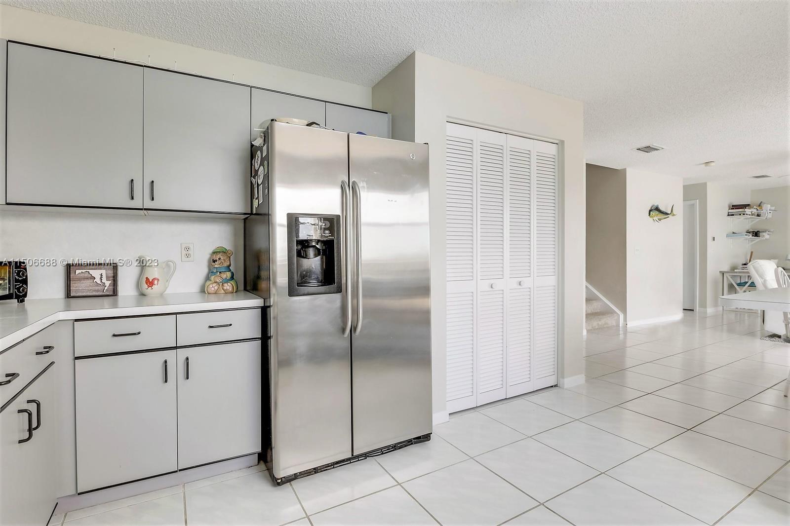 7289 Shell Ridge Terrace Lake Worth, FL 33467 - Photo 17 of 55 a kitchen with white cabinets and refrigerator