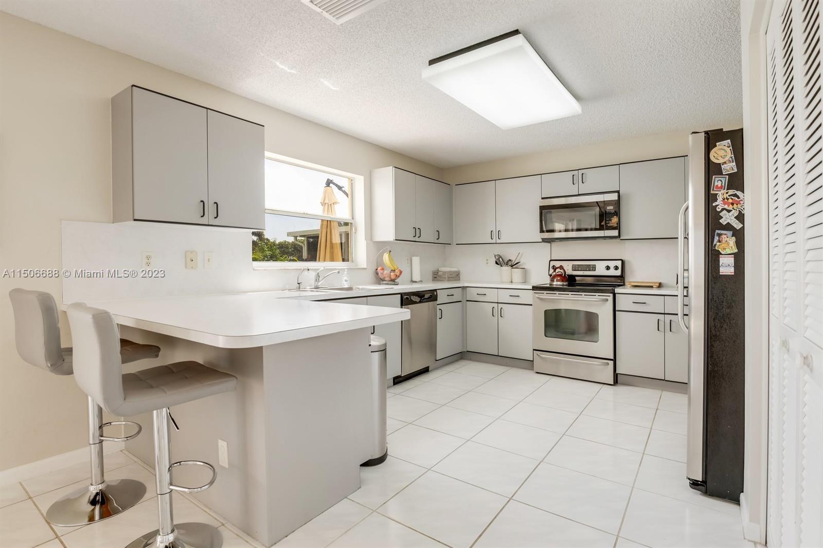 7289 Shell Ridge Terrace Lake Worth, FL 33467 - Photo 18 of 55 a kitchen with white cabinets and white appliances