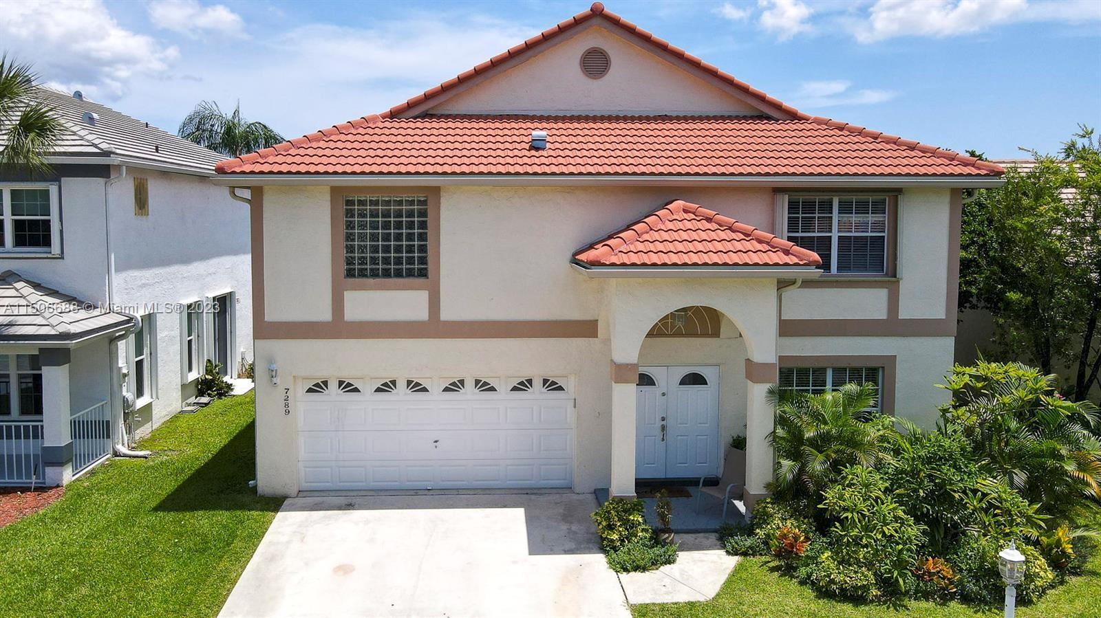 7289 Shell Ridge Terrace Lake Worth, FL 33467 - Photo 2 of 55 a front view of a house with a garden