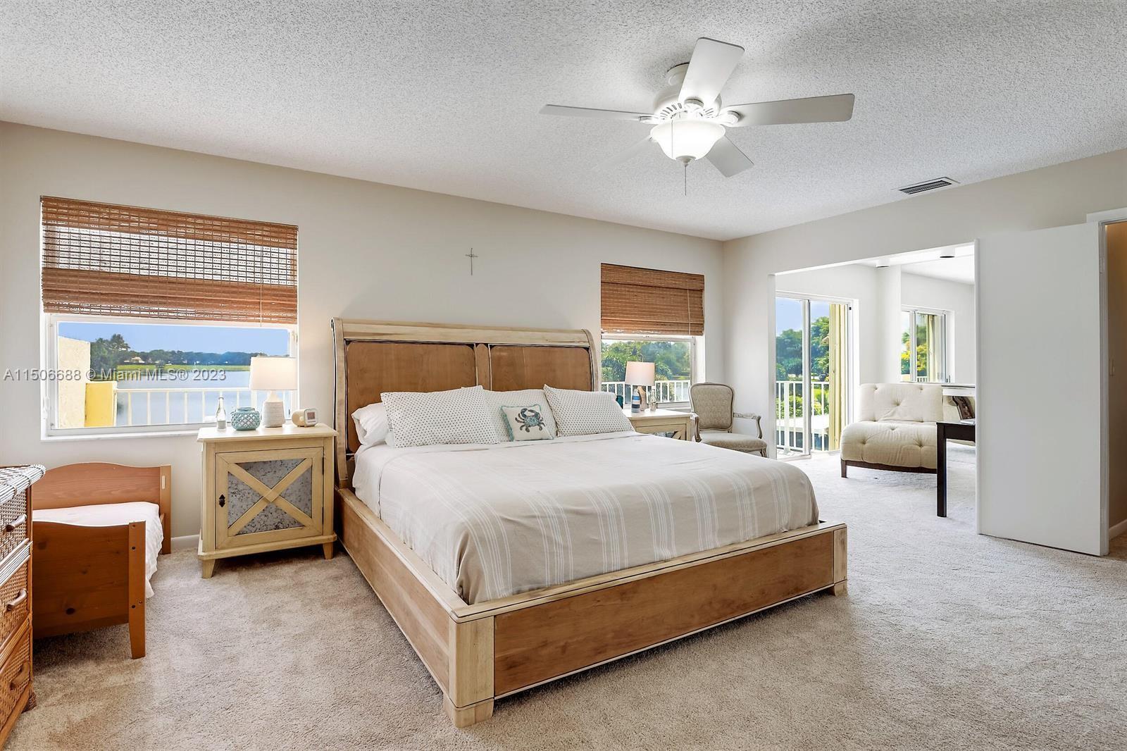 7289 Shell Ridge Terrace Lake Worth, FL 33467 - Photo 26 of 55 a spacious bedroom with a bed and a chandelier
